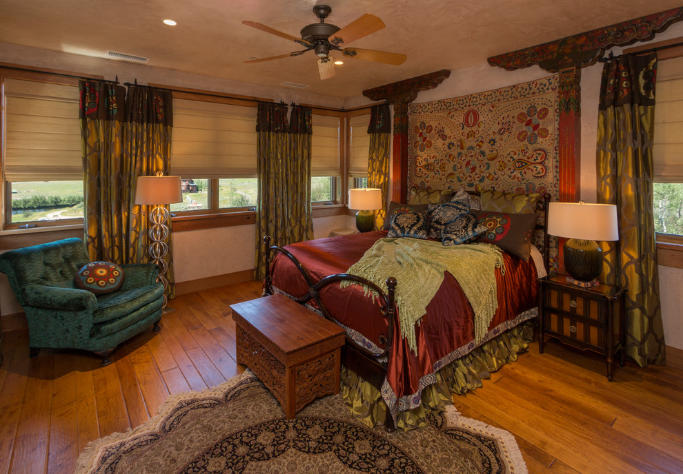 Photo of a large mediterranean guest bedroom in Denver with light hardwood floors and beige walls.