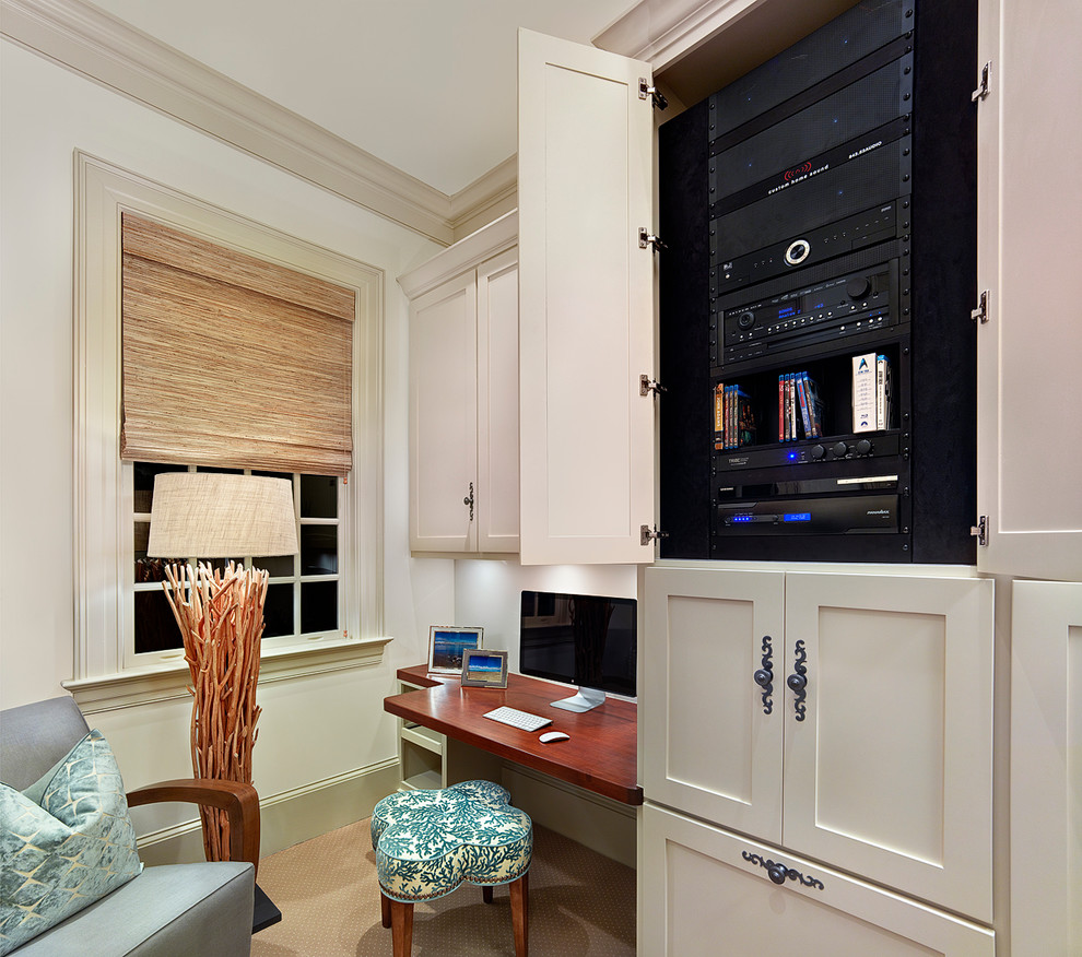 Example of a small beach style built-in desk carpeted and beige floor study room design in Charleston with white walls