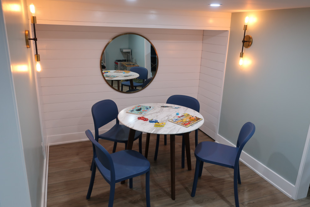 Photo of a mid-sized eclectic gender-neutral kids' playroom for kids 4-10 years old in Philadelphia with blue walls, light hardwood floors and brown floor.