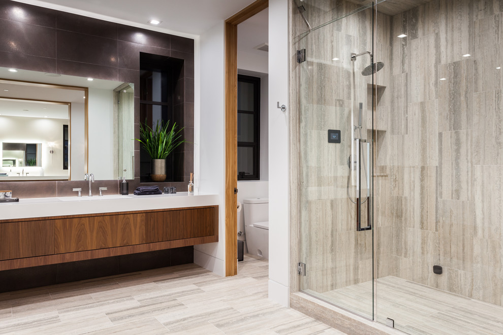 Expansive contemporary master bathroom in Orange County with flat-panel cabinets, medium wood cabinets, an alcove shower, a one-piece toilet, black tile, marble, multi-coloured walls, marble floors, an integrated sink, multi-coloured floor and white benchtops.
