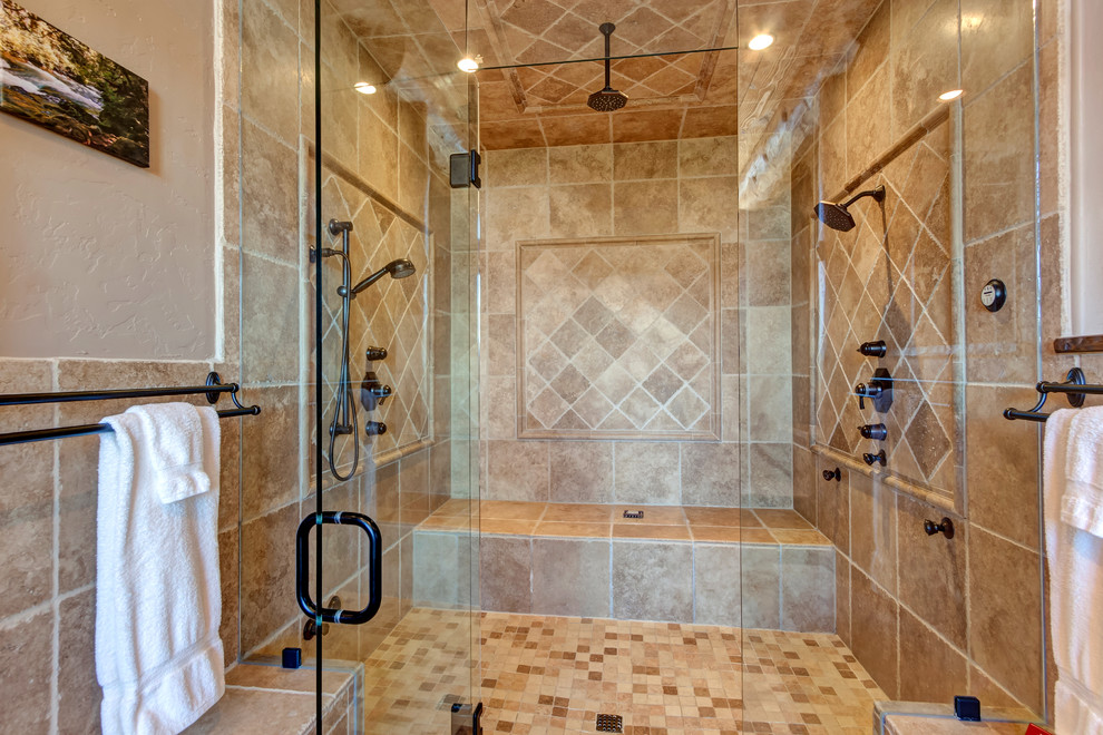 Design ideas for a large country master bathroom in Denver with louvered cabinets, dark wood cabinets, a drop-in tub, an alcove shower, beige tile, limestone, beige walls, limestone floors, an undermount sink, limestone benchtops, multi-coloured floor, a hinged shower door and multi-coloured benchtops.