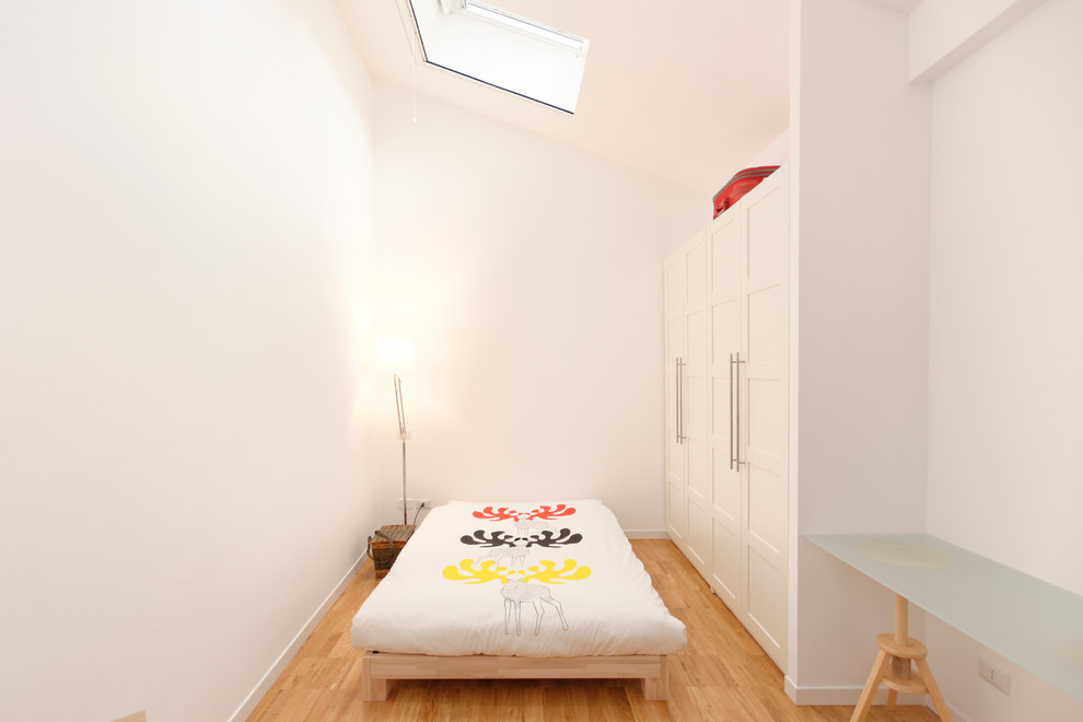Photo of a mid-sized scandinavian bedroom in Milan with white walls and light hardwood floors.