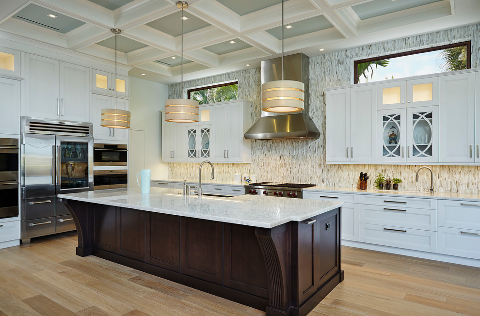 This is an example of a large transitional l-shaped separate kitchen in Miami with an undermount sink, shaker cabinets, white cabinets, marble benchtops, multi-coloured splashback, matchstick tile splashback, stainless steel appliances, light hardwood floors, with island and brown floor.
