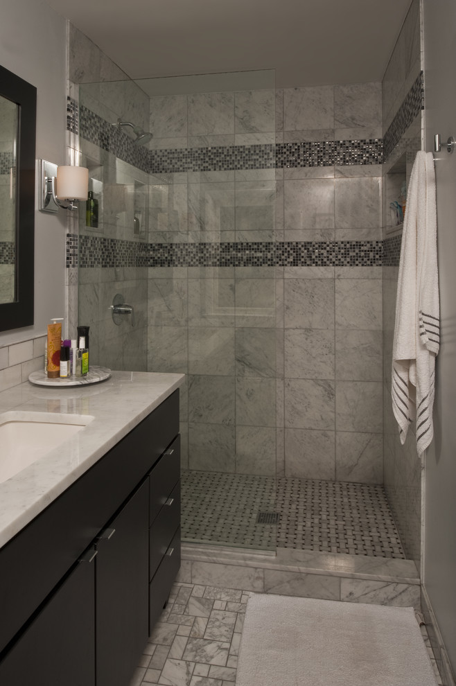 This is an example of a mid-sized contemporary master bathroom in Detroit with flat-panel cabinets, black cabinets, a curbless shower, a one-piece toilet, white tile, ceramic tile, grey walls, marble floors, an undermount sink and quartzite benchtops.