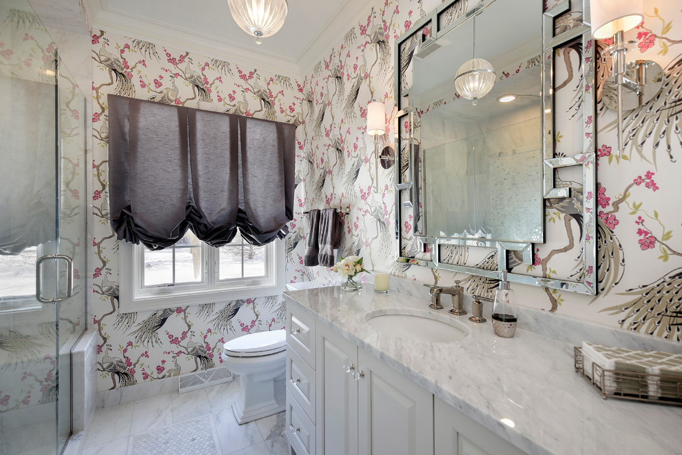 Photo of a mid-sized transitional powder room in Chicago with an undermount sink, raised-panel cabinets, white cabinets, marble benchtops and white benchtops.
