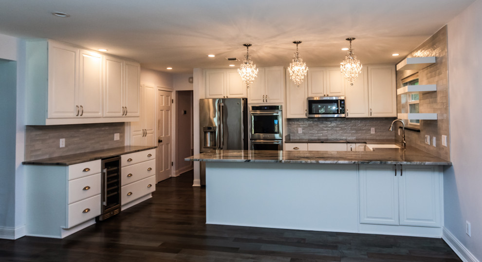 Mid-sized transitional u-shaped eat-in kitchen with white cabinets and stainless steel appliances.