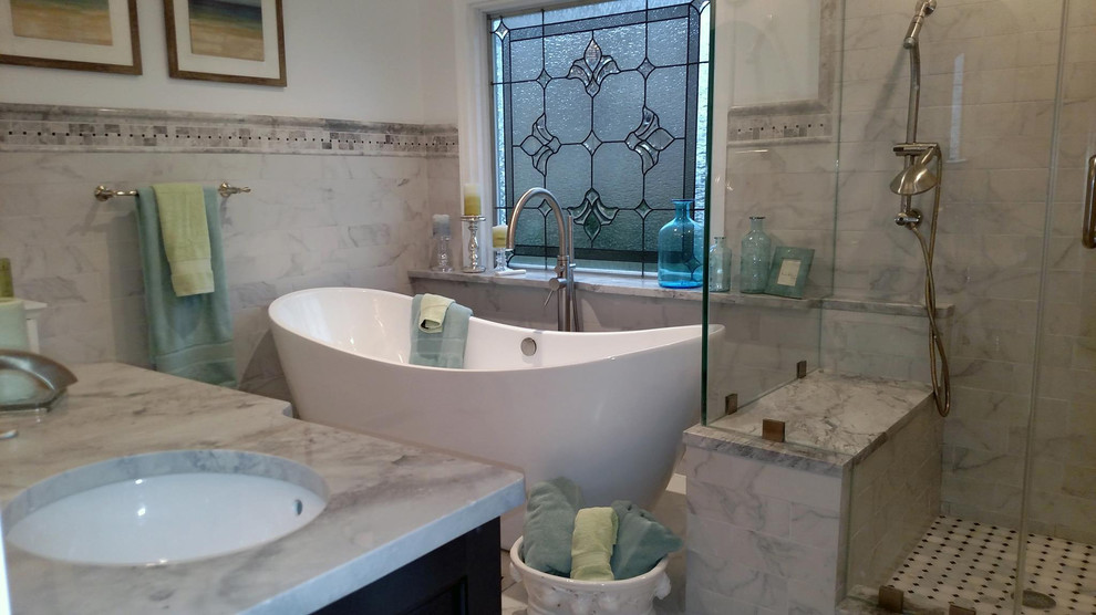 Freestanding bathtub - mid-sized transitional master black and white tile and porcelain tile porcelain tile freestanding bathtub idea with white walls, an undermount sink, granite countertops, gray cabinets and a two-piece toilet