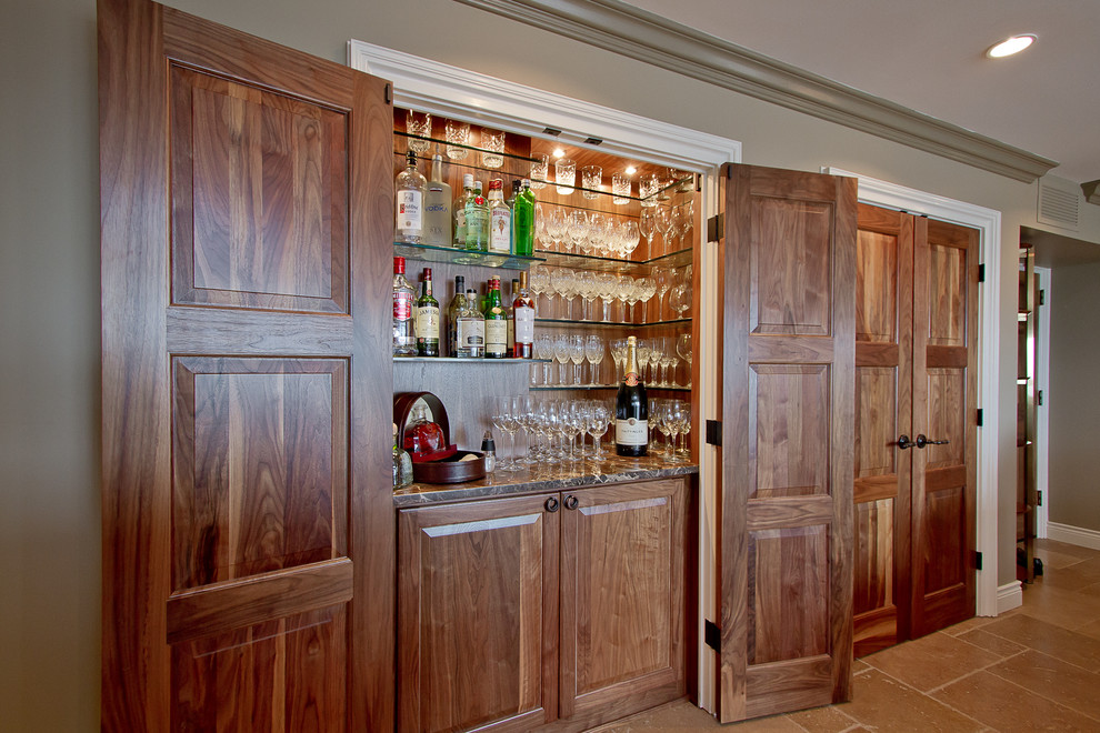 Design ideas for a small traditional home bar with raised-panel cabinets, dark wood cabinets, marble benchtops and ceramic floors.