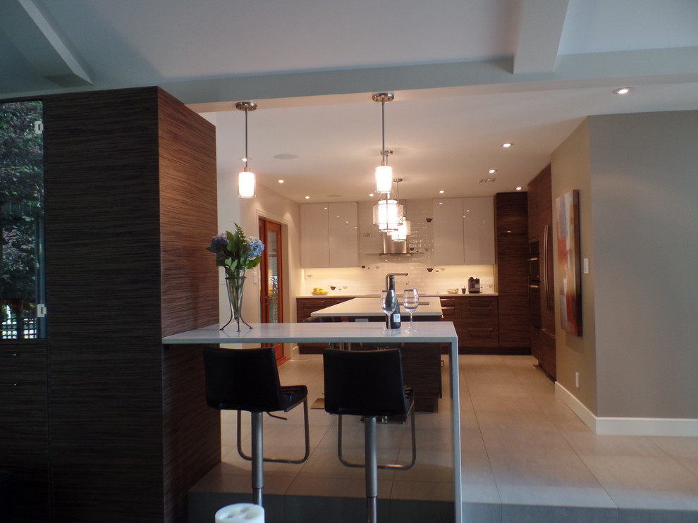 Example of a mid-sized transitional l-shaped porcelain tile and beige floor enclosed kitchen design with an undermount sink, flat-panel cabinets, medium tone wood cabinets, quartz countertops, white backsplash, subway tile backsplash, paneled appliances and an island