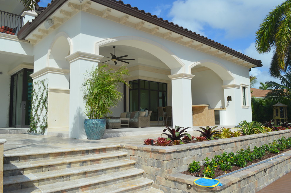 Large mediterranean two-storey stucco white house exterior in Miami with a gable roof and a shingle roof.