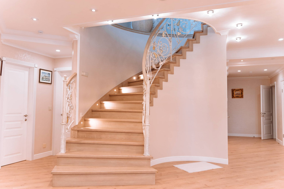 Стильный дизайн: большая изогнутая деревянная лестница в стиле модернизм с деревянными ступенями, деревянными перилами и кирпичными стенами - последний тренд
