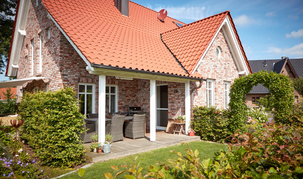 Große, Überdachte Landhausstil Terrasse neben dem Haus in Bremen