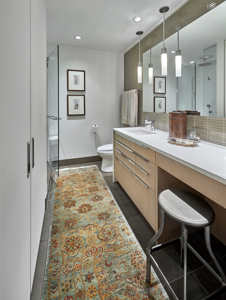 Design ideas for a contemporary master bathroom in Chicago with flat-panel cabinets, light wood cabinets, a one-piece toilet, beige tile, glass tile, white walls, limestone floors, an undermount sink, engineered quartz benchtops, grey floor, a hinged shower door, white benchtops, a single vanity and a built-in vanity.
