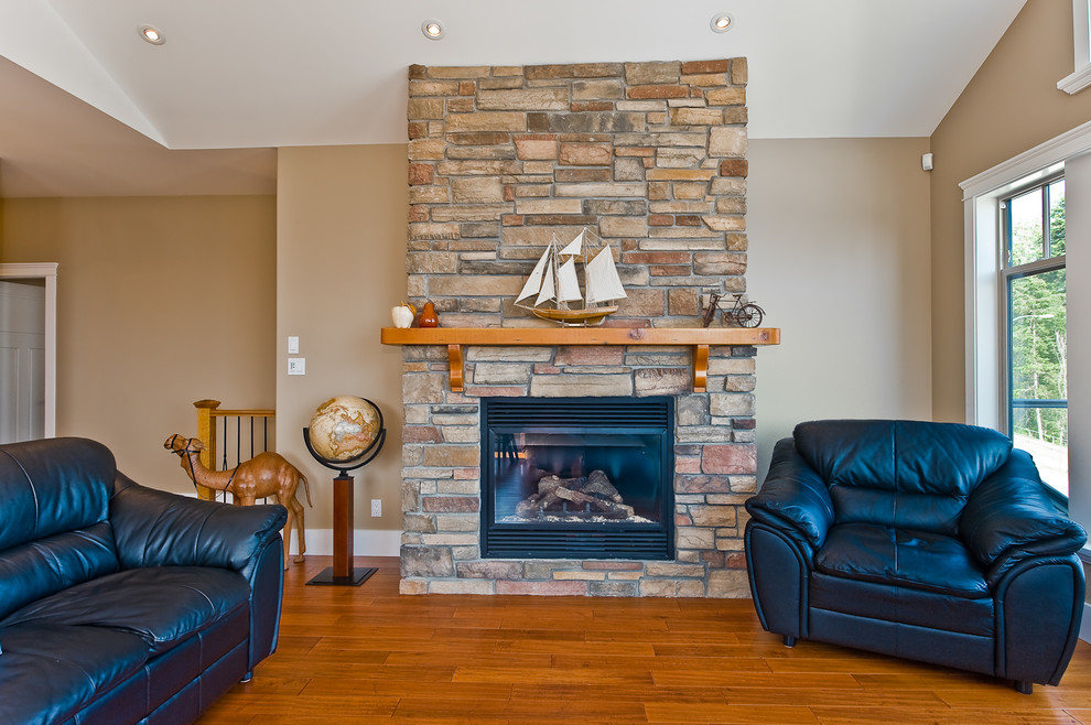 This is an example of a mid-sized transitional open concept family room in Vancouver with beige walls, medium hardwood floors, a standard fireplace and a brick fireplace surround.