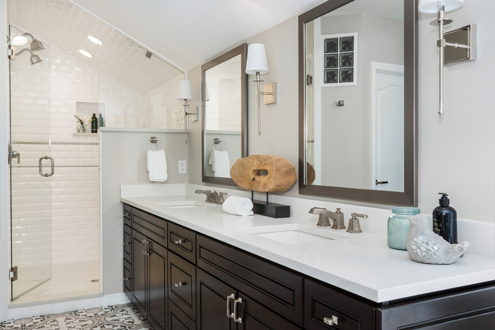 Design ideas for a mid-sized transitional master bathroom in Denver with raised-panel cabinets, dark wood cabinets, a freestanding tub, an alcove shower, a two-piece toilet, gray tile, ceramic tile, grey walls, porcelain floors, an undermount sink, engineered quartz benchtops, grey floor, a hinged shower door and white benchtops.