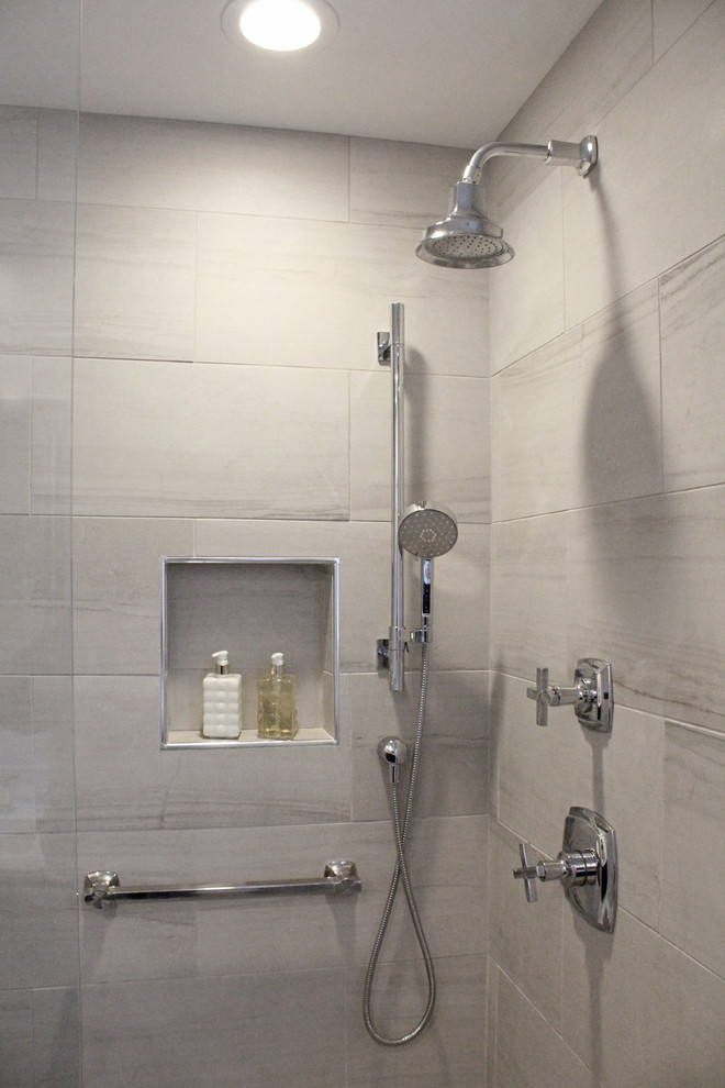 Corner shower - mid-sized transitional master gray tile and porcelain tile porcelain tile corner shower idea in Boston with shaker cabinets, dark wood cabinets, a two-piece toilet, gray walls, an undermount sink and quartz countertops