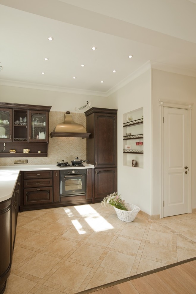 Design ideas for a mid-sized traditional l-shaped kitchen in Moscow with raised-panel cabinets, dark wood cabinets, beige splashback, black appliances and no island.