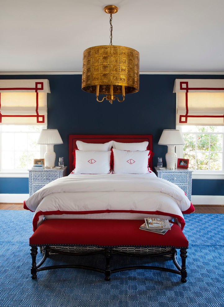 This is an example of a transitional bedroom in Charlotte with blue walls and dark hardwood floors.