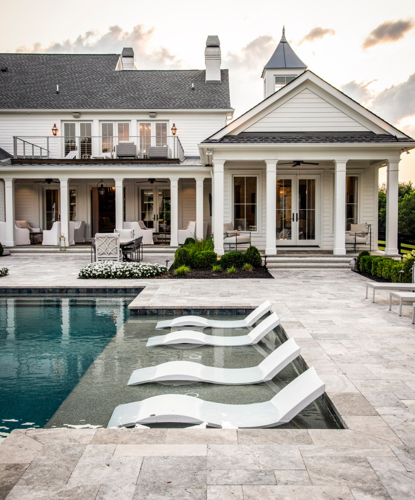 This is an example of a large country back custom shaped swimming pool in Nashville with natural stone paving.
