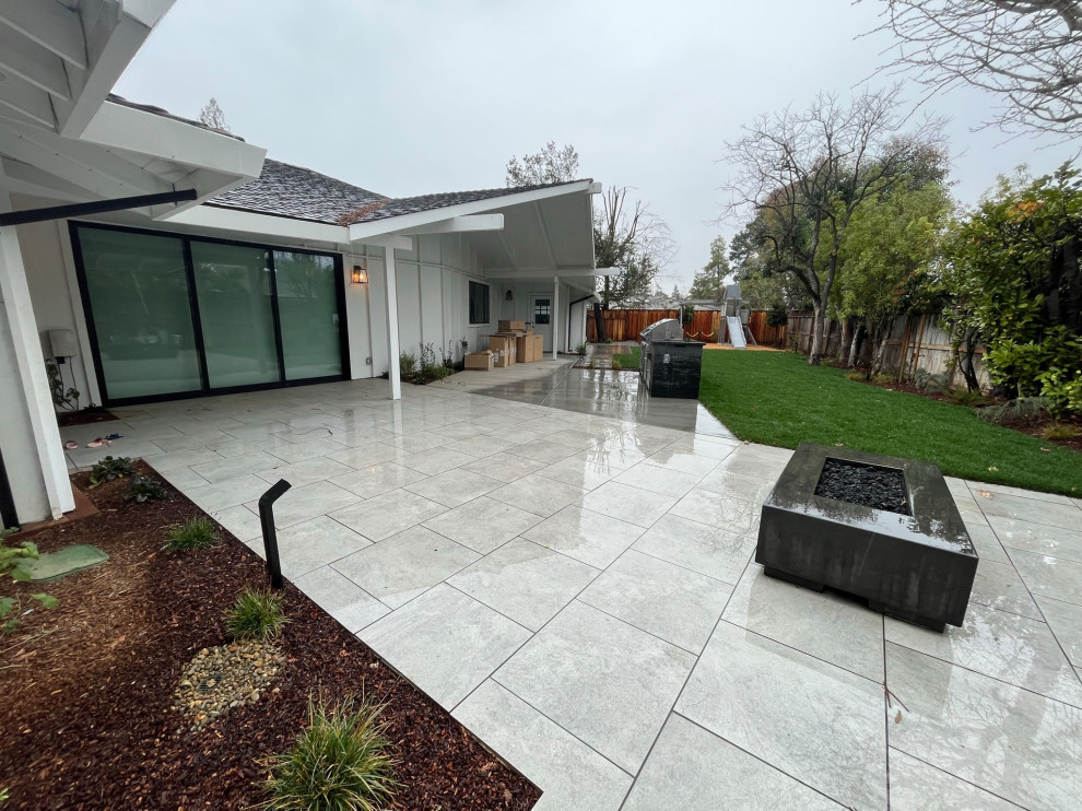 Immagine di un grande patio o portico design dietro casa con pavimentazioni in cemento e un parasole