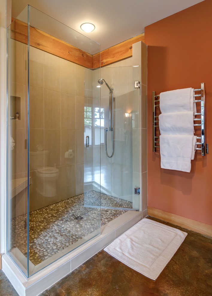 This is an example of an arts and crafts master bathroom in Seattle with dark wood cabinets, a corner shower, beige tile, porcelain tile, concrete floors, a drop-in tub, an undermount sink, granite benchtops and a hinged shower door.