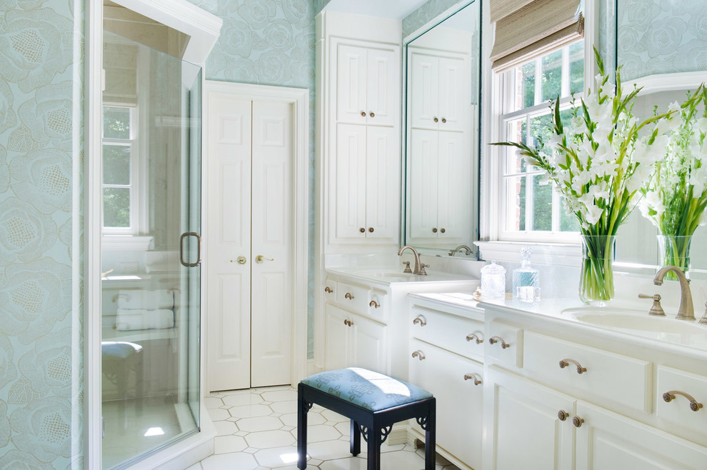 Inspiration for a traditional master bathroom in Charlotte with an integrated sink, raised-panel cabinets, white cabinets, a corner shower, blue walls, mosaic tile floors, engineered quartz benchtops, white floor and a hinged shower door.