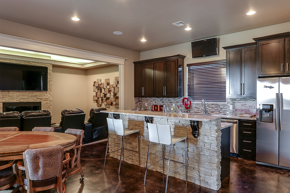 This is an example of an expansive contemporary single-wall seated home bar in Oklahoma City with an undermount sink, shaker cabinets, dark wood cabinets, marble benchtops, multi-coloured splashback, glass tile splashback and concrete floors.