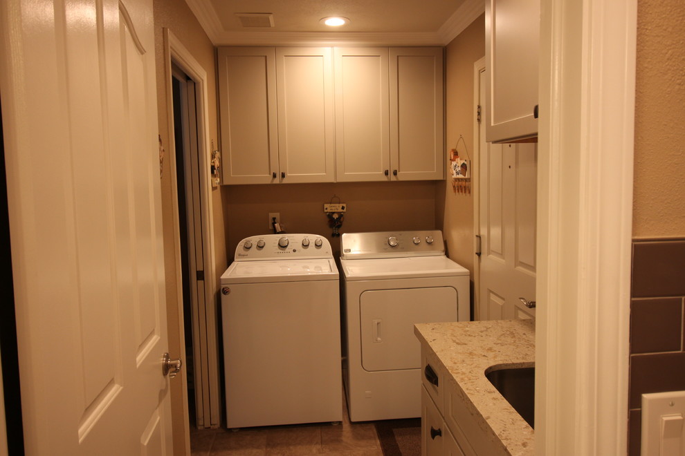 This is an example of a small country galley dedicated laundry room in Other with an undermount sink, shaker cabinets, white cabinets, quartz benchtops, beige walls, laminate floors, a side-by-side washer and dryer and brown floor.