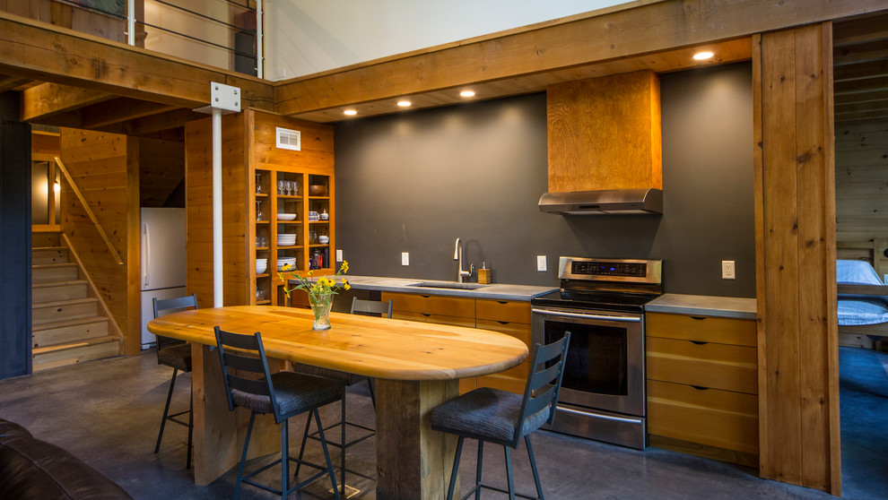 Small mountain style single-wall concrete floor and gray floor open concept kitchen photo in Ottawa with an undermount sink, flat-panel cabinets, medium tone wood cabinets, concrete countertops, gray backsplash, stainless steel appliances and an island
