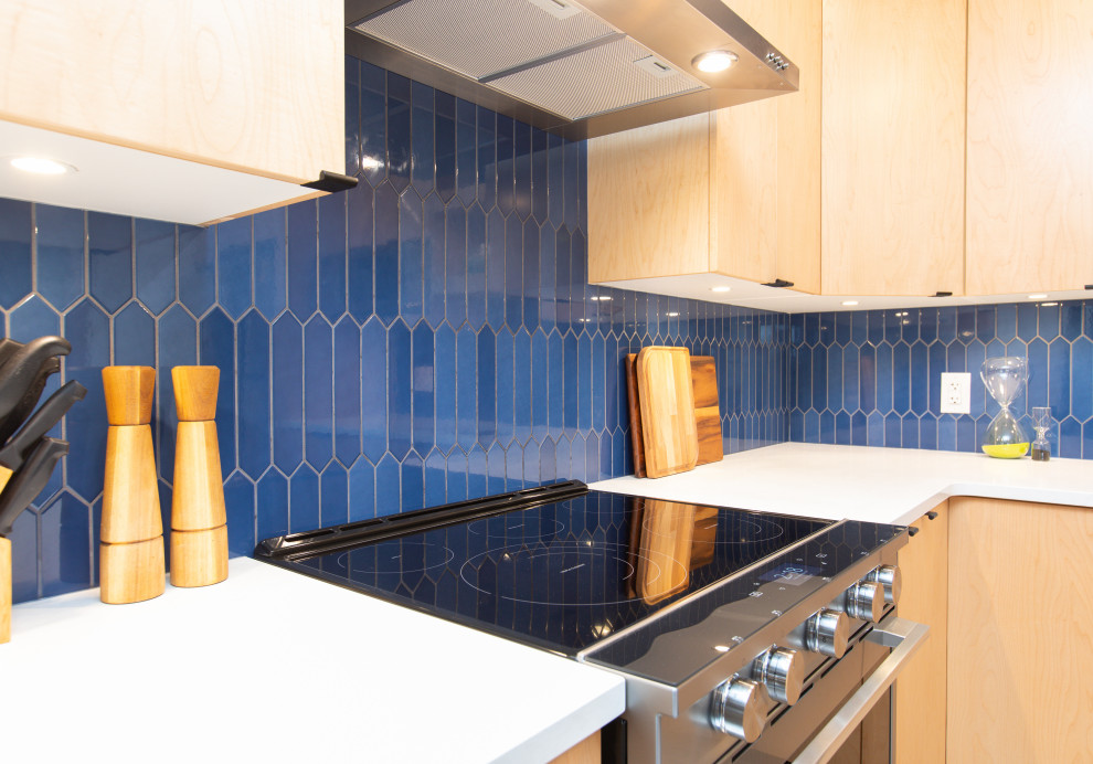 This is an example of a mid-sized modern l-shaped separate kitchen in Other with an undermount sink, flat-panel cabinets, light wood cabinets, quartz benchtops, blue splashback, ceramic splashback, stainless steel appliances, vinyl floors, no island, beige floor and white benchtop.