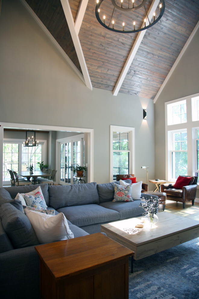 Imagen de salón abierto costero de tamaño medio con paredes beige y suelo de madera en tonos medios