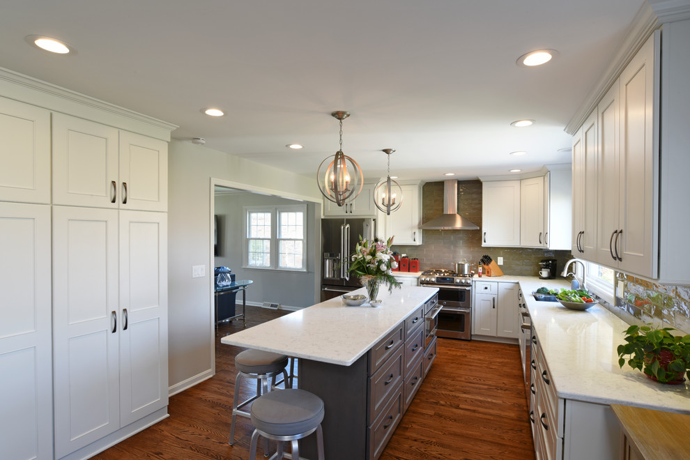 Inspiration for a transitional l-shaped medium tone wood floor eat-in kitchen remodel in Orange County with a double-bowl sink, shaker cabinets, white cabinets, marble countertops, gray backsplash, glass tile backsplash, stainless steel appliances and an island