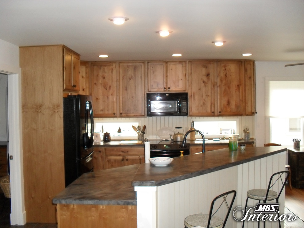Inspiration for a rustic l-shaped eat-in kitchen remodel with a double-bowl sink, shaker cabinets, medium tone wood cabinets, solid surface countertops, white backsplash and black appliances