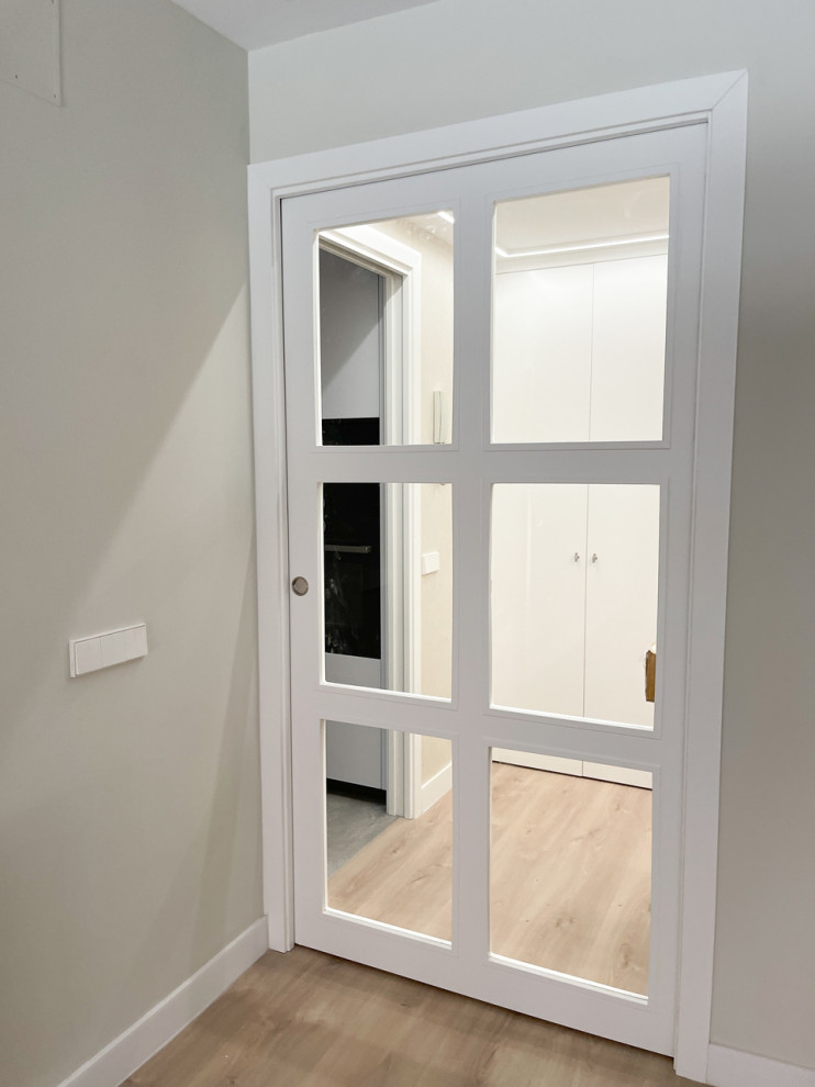 Idee per una porta d'ingresso moderna di medie dimensioni con pareti beige, pavimento in legno massello medio e carta da parati