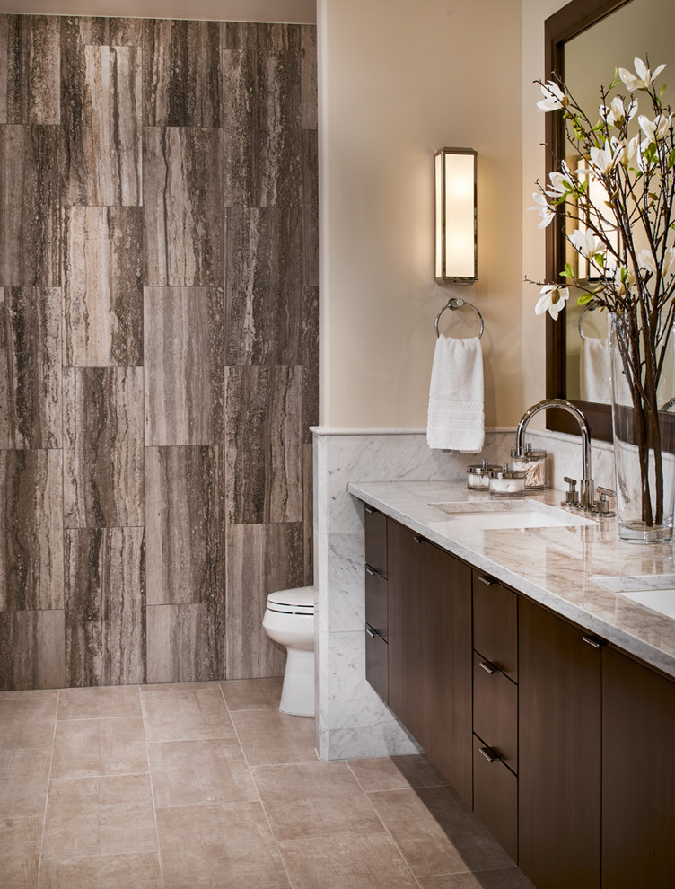 Inspiration for a mid-sized contemporary master bathroom in Denver with an undermount sink, flat-panel cabinets, dark wood cabinets, marble benchtops, a drop-in tub, a corner shower, a two-piece toilet, white tile, porcelain tile, beige walls and porcelain floors.