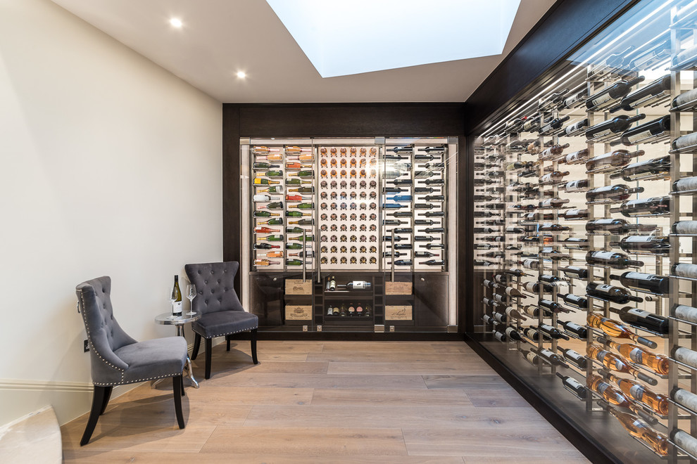 Inspiration for a mid-sized contemporary wine cellar in London with display racks.