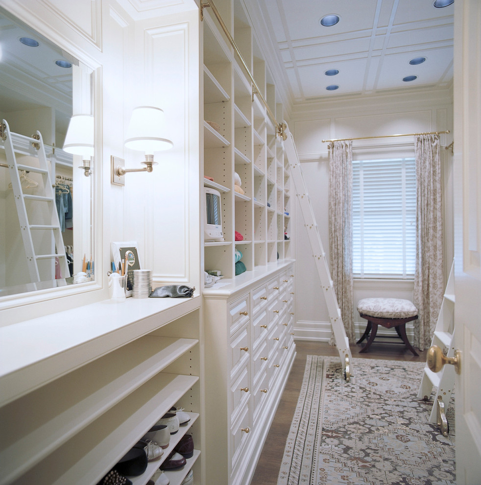 Large traditional gender-neutral dressing room in New York with raised-panel cabinets, white cabinets and medium hardwood floors.
