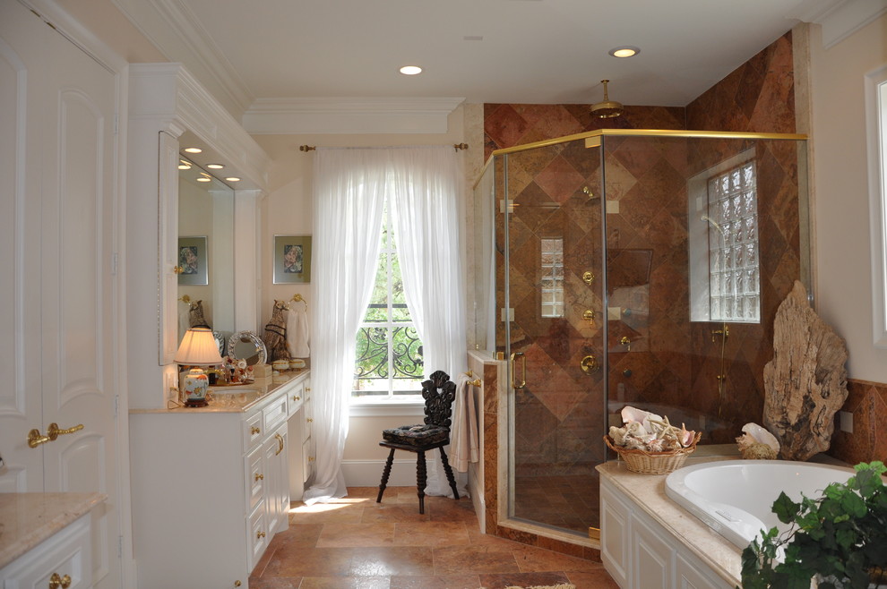 Photo of a mid-sized traditional master bathroom with beaded inset cabinets, white cabinets, a drop-in tub, a corner shower, a one-piece toilet, beige walls, an undermount sink, orange tile, travertine, travertine floors, marble benchtops, orange floor and a hinged shower door.