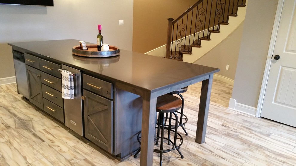 Large country single-wall seated home bar in Kansas City with an undermount sink, shaker cabinets, dark wood cabinets, solid surface benchtops, white splashback, subway tile splashback, vinyl floors, brown floor and brown benchtop.