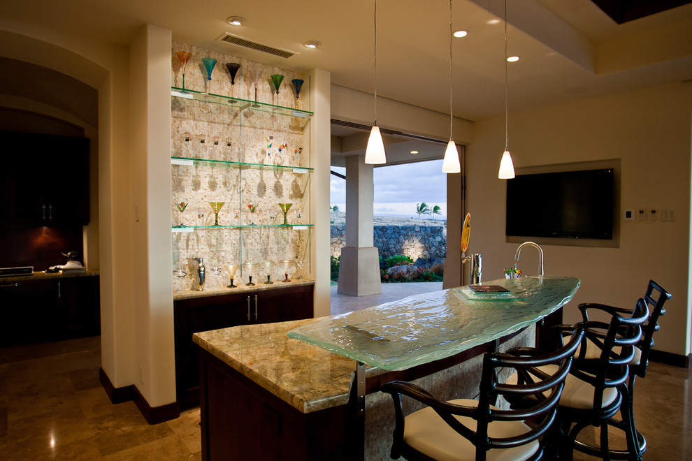 This is an example of a mid-sized transitional galley seated home bar in Hawaii with an undermount sink, open cabinets, dark wood cabinets, glass benchtops, white splashback, mosaic tile splashback, porcelain floors and beige floor.