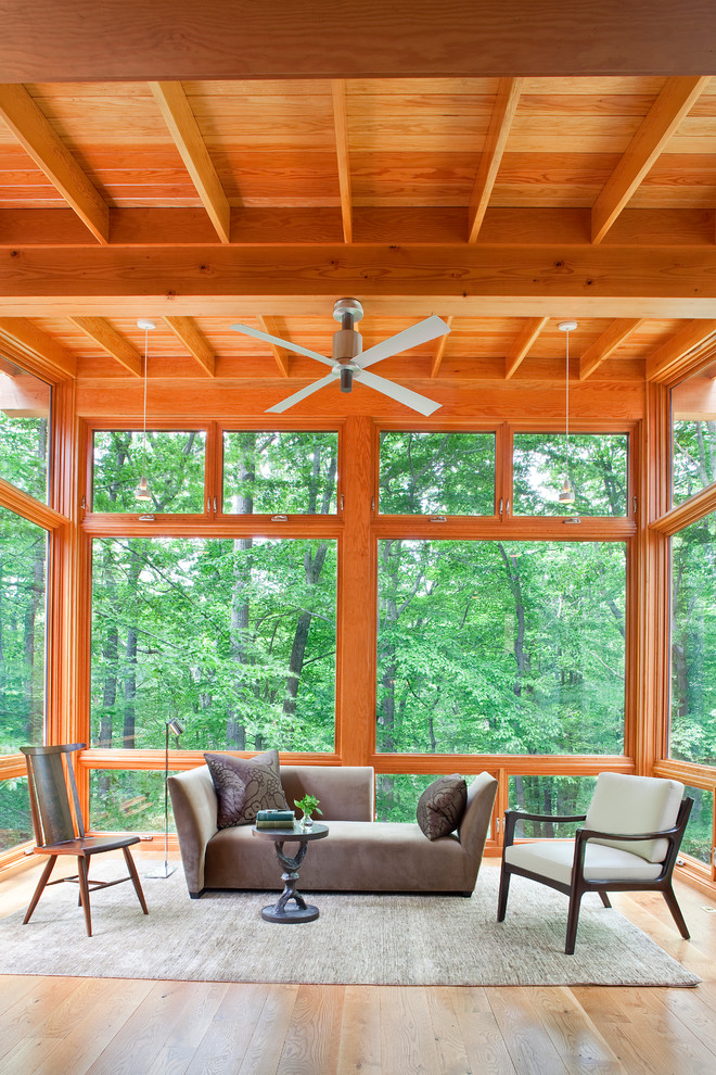Photo of a country sunroom in DC Metro with a standard ceiling and brown floor.