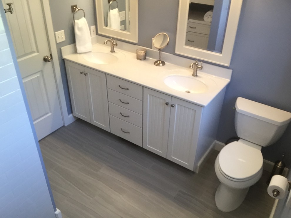 Design ideas for a small country master bathroom in Seattle with beaded inset cabinets, white cabinets, a two-piece toilet, blue walls, porcelain floors, an integrated sink, onyx benchtops and grey floor.