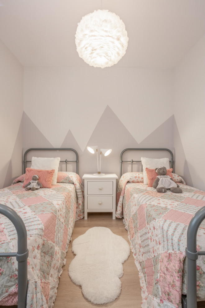 Photo of a small transitional kids' bedroom for kids 4-10 years old and girls in Madrid with grey walls, laminate floors and brown floor.