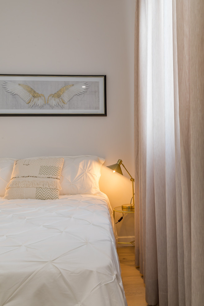 Imagen de habitación de invitados beige y blanca clásica renovada pequeña con paredes blancas, suelo de madera en tonos medios y suelo marrón