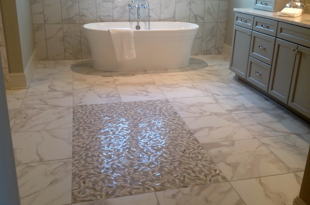 Freestanding bathtub - large transitional master gray tile and marble tile marble floor and multicolored floor freestanding bathtub idea with recessed-panel cabinets, gray cabinets, beige walls and quartz countertops