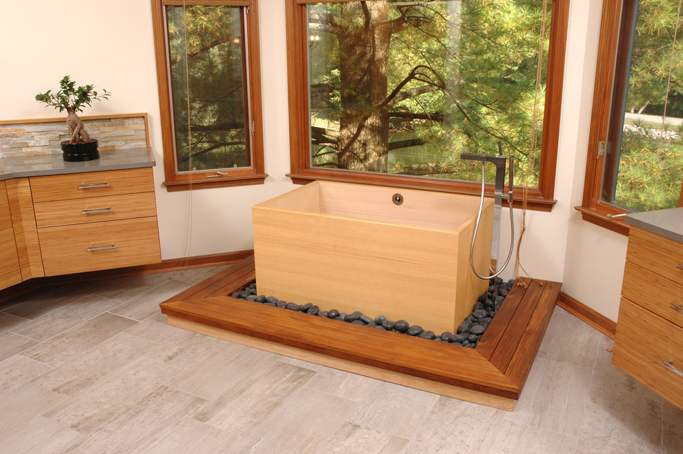 Inspiration for a mid-sized asian master bathroom in Cincinnati with flat-panel cabinets, light wood cabinets, a japanese tub, beige walls and engineered quartz benchtops.