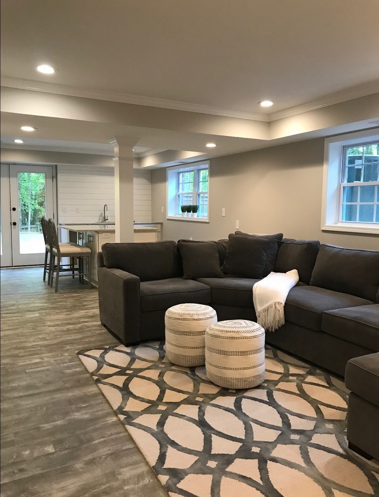 This is an example of a mid-sized contemporary walk-out basement in Atlanta with grey walls, vinyl floors and grey floor.