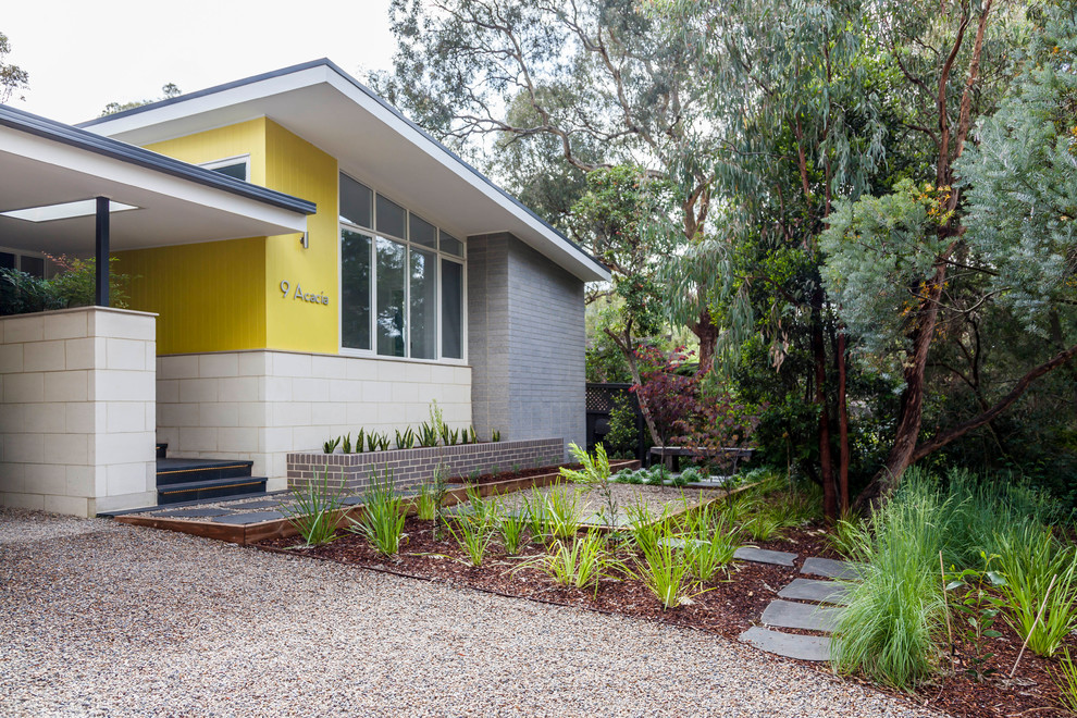 Design ideas for a mid-sized midcentury two-storey house exterior in Melbourne with mixed siding.