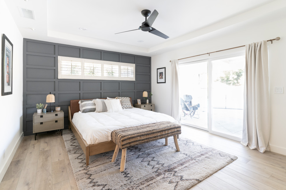 Photo of a large transitional master bedroom in Orange County with vinyl floors, no fireplace, brown floor, recessed and decorative wall panelling.