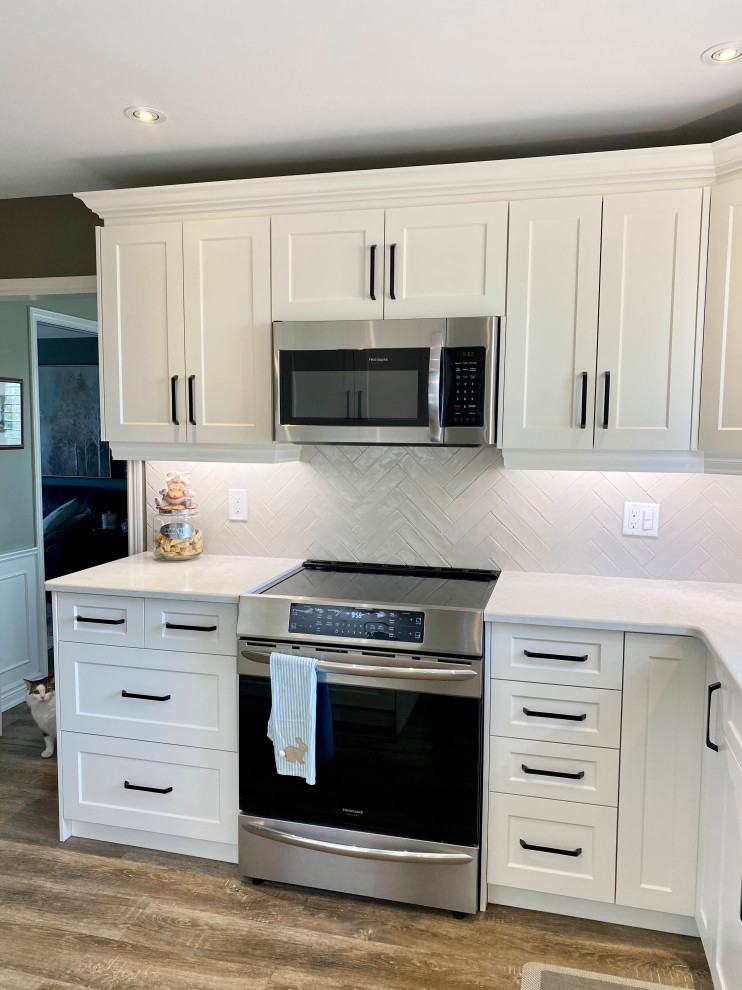 Mid-sized transitional l-shaped enclosed kitchen photo with a double-bowl sink, recessed-panel cabinets, white cabinets, gray backsplash, glass tile backsplash and no island